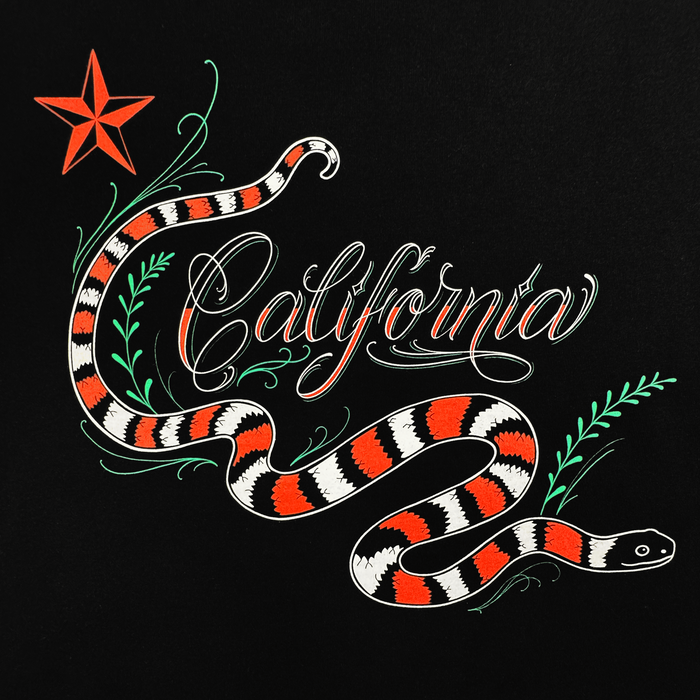 The Oaklandish CA King Tee features a red, black, and white snake winding around “California” in cursive, with a red star and green leafy branches on bold graphics—perfectly printed on a classic fit men's black t-shirt.