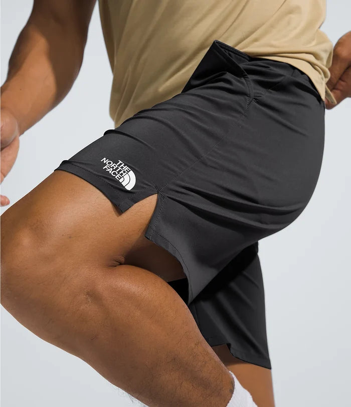 Person wearing black athletic shorts with The North Face logo on a light gray background