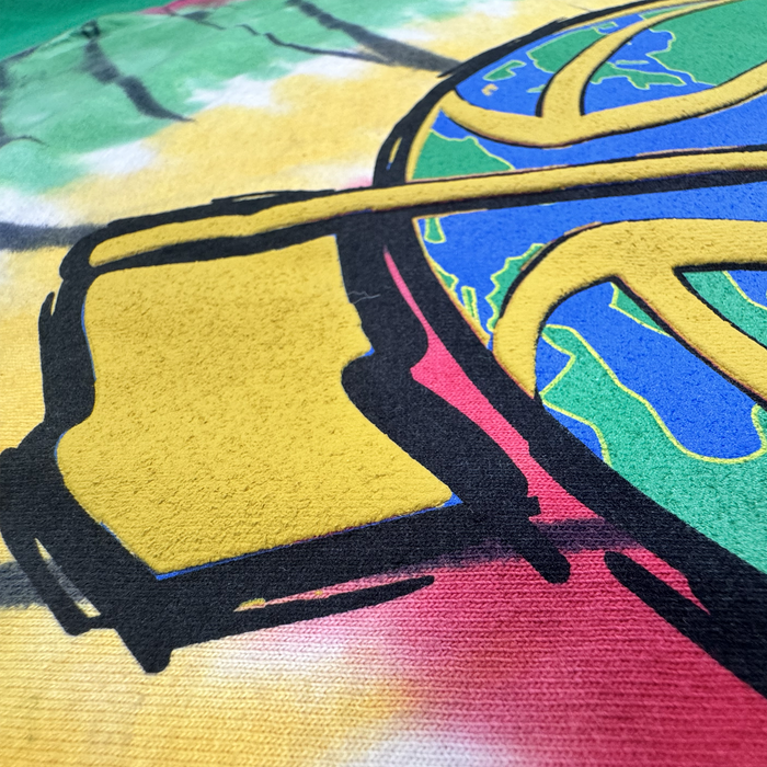 A close-up of colorful street art featuring bold black outlines, a yellow square, and a partial globe with visible continents, set against a background blending green, yellow, and red hues with a textured canvas surfaceโreminiscent of the vibrant patterns found on The Dead Golf Tee By Doc by By DOC, crafted from heavyweight cotton in a classic fit.