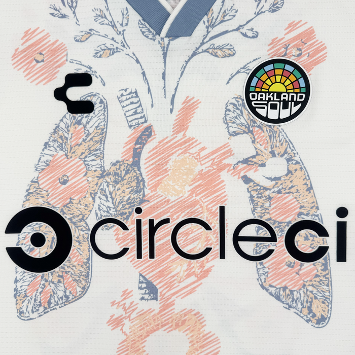 A close-up of the 2026 Oakland Soul SC Form Jersey by Oakland Soul, made from premium polyester, features an abstract floral lung pattern, stylized circleci logo, black emblem, and an "Oakland Soul" patch with blue and orange flowers.