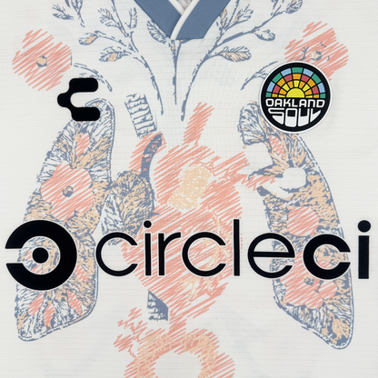 A close-up of the 2026 Oakland Soul SC Form Jersey by Oakland Soul, made from premium polyester, features an abstract floral lung pattern, stylized circleci logo, black emblem, and an "Oakland Soul" patch with blue and orange flowers.