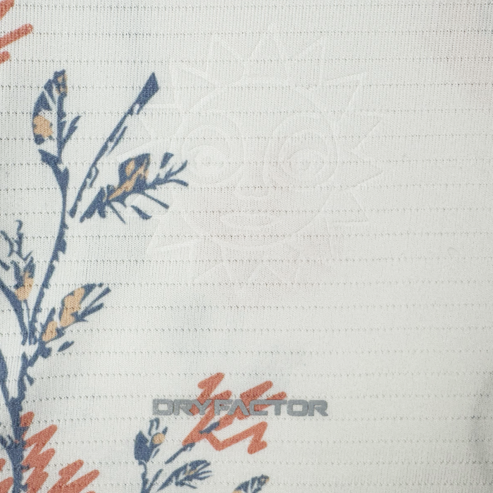 A close-up of textured white fabric on the 2026 OAKLAND SOUL SC FORM JERSEY by Oakland Soul shows blue and orange floral prints, a subtle sun with a face, and “DRYFACTOR” in gray text near the bottom center. Made from high-quality polyester.