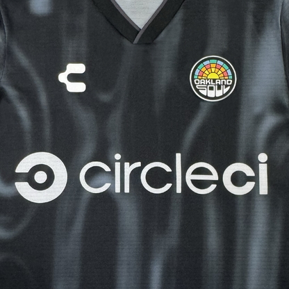The 2026 Oakland Soul SC Spirit Jersey by Oakland Soul is a black polyester top with a white "circleci" logo on the chest, white "C" on the left, colorful Oakland Soul badge on the right, and a V-shaped black collar.