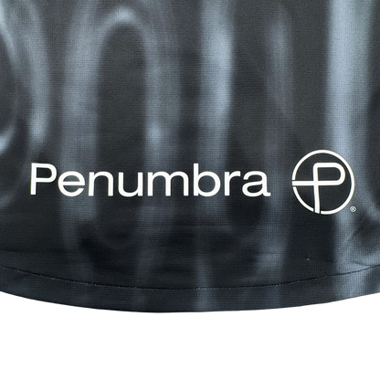 The 2026 Oakland Soul SC Spirit Jersey by Oakland Soul features a black polyester background with "Penumbra" in white and a stylized "P" circular logo, accented by a subtle wavy pattern and visible bottom edge for a classic jersey look.