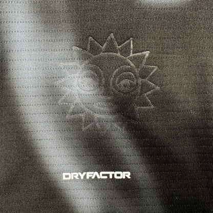 A close-up of the 2026 OAKLAND SOUL SC SPIRIT JERSEY by Oakland Soul reveals a textured dark polyester fabric with an embossed smiling sun and radiating rays, plus bold white "DRYFACTOR" text highlighted by a subtle gradient of light and shadow.