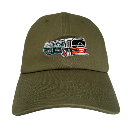 The Oaklandish AC Transit Dad Hat features an olive green, unstructured low-profile design with a retro bus embroidery inspired by classic Latin American buses and East Bay’s AC Transit, adding casual local flair.