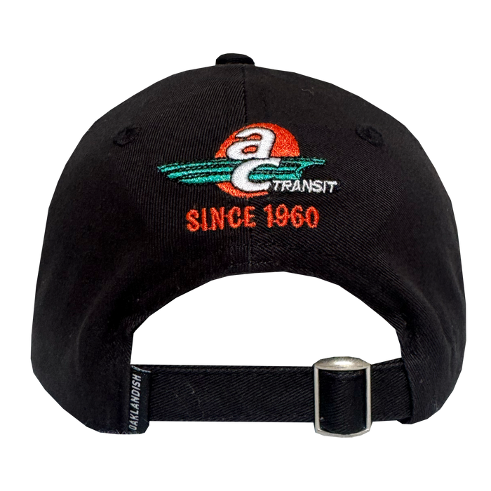 Back view of the AC Transit Dad Hat by Oaklandish, a black cap with an embroidered AC Transit logo (red sun, teal swooshes, "Since 1960" in orange), adjustable black strap with silver buckle, and Oaklandish label—celebrating East Bay pride.