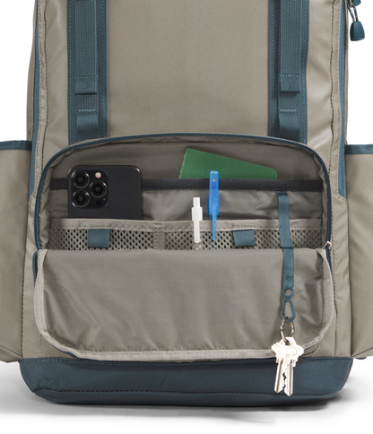 Close-up of a backpack with compartments and items inside on a white background