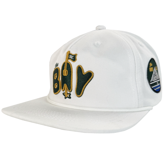 The Bay Area 5 Panel by DOC from Oaklandish is a white, unstructured baseball cap with stylized yellow and black "Bay" text and a flag graphic. Part of The Bay Collection, it features a flat brim, visible stitching, and an adjustable strap back.