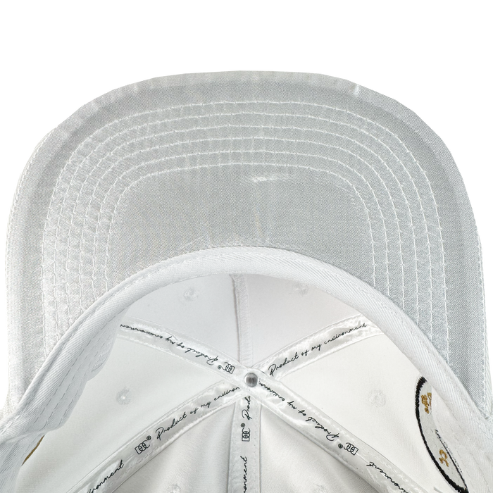A close-up of the underside of the white Bay Area 5 Panel by DOC from Oaklandish, featuring detailed stitching on the brim and panels, printed text, illustrations, and ventilation holes throughout.