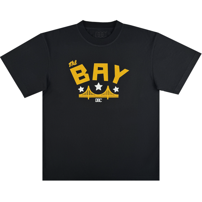 The Bay Bridge Tee By DOC V2 by Oaklandish features a classic fit in heavyweight cotton with bold yellow "The BAY" text, three white stars, and a yellow bridge graphic inspired by the Golden Gate Bridge on the chest.