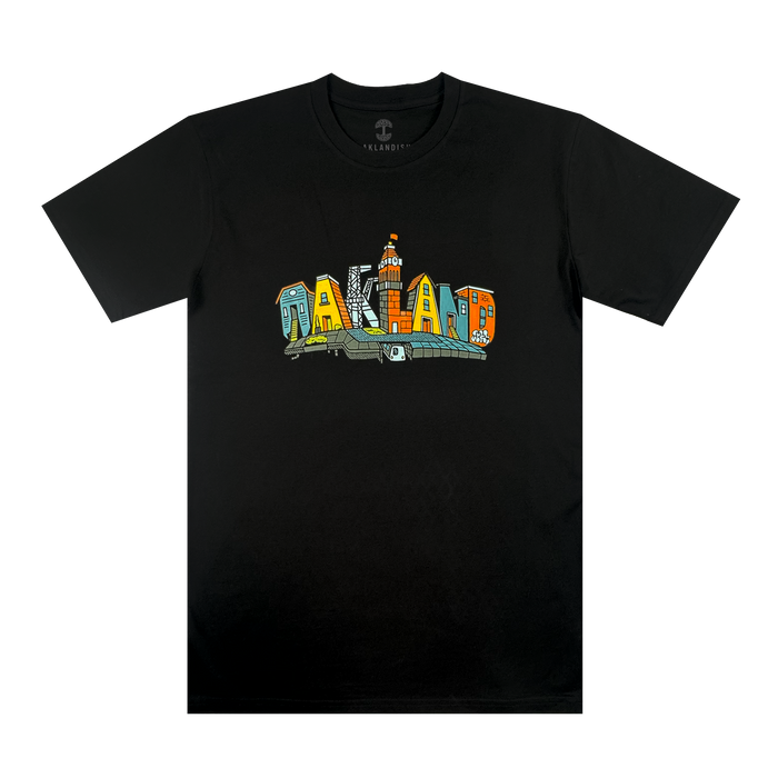 The Blockletters Tee by Oaklandish features "OAKLAND" in bold, colorful block letters with playful patterns. A small illustrated building above the "L" adds a touch of cityscape detail to this vibrant black t-shirt.