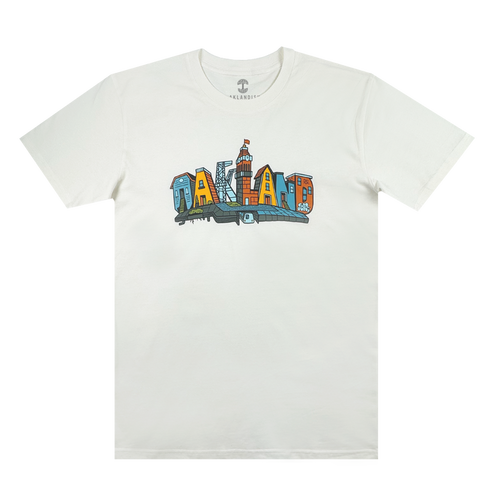 The Blockletters Tee by Oaklandish showcases “OAKLAND” in bold, colorful cityscape letters above a blue skyline, celebrating local landmarks with a vibrant urban design.