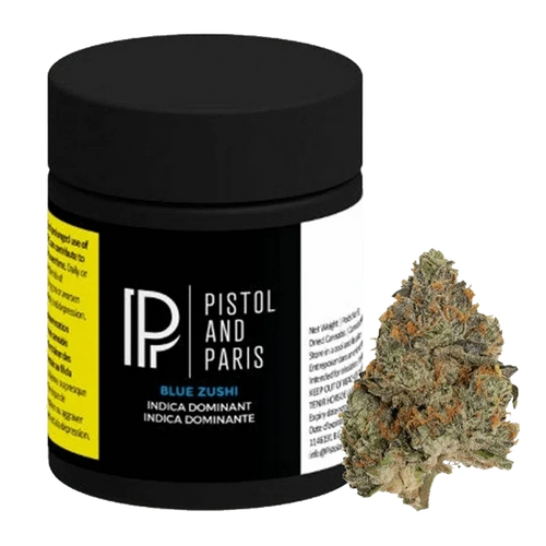 Front three-quarter view of a black Pistol and Paris Blue Zushi jar with label details visible, shown beside a single green and orange cannabis bud.