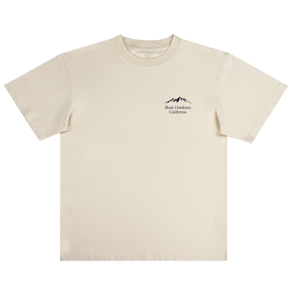 The Bosk Outdoors Tee by Other is a men’s short-sleeved, off-white heavyweight cotton T-shirt featuring a small black line art of mountains above the words “Back Outdoors California” on the upper left chest. The shirt is shown laid flat on a white background.