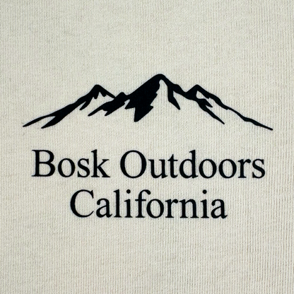 Featuring a black outline of a mountain range above the words “Bosk Outdoors California,” the Other Bosk Outdoors Tee is printed on a light-colored, heavyweight cotton fabric. The bold, clear lettering and centered design add to its modern look. Designed in an oversized fit and available in men’s sizing, this t-shirt ensures comfort for every outdoor adventure.