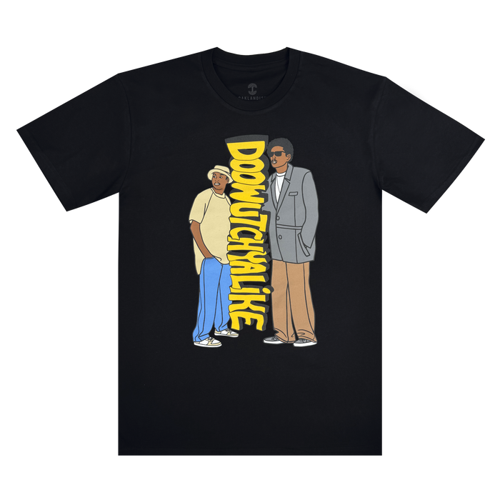 The Doowutchyalike Tee by Other is a black t-shirt featuring cartoon illustrations of two men side by side—one dressed casually with sunglasses, the other in a gray suit—with bold yellow “DOOWUTCHYALIKE” text displayed between them. Inspired by classic Oaklandish apparel and 90s hip hop culture, this Digital Underground-themed shirt makes a vibrant statement against a plain white background.