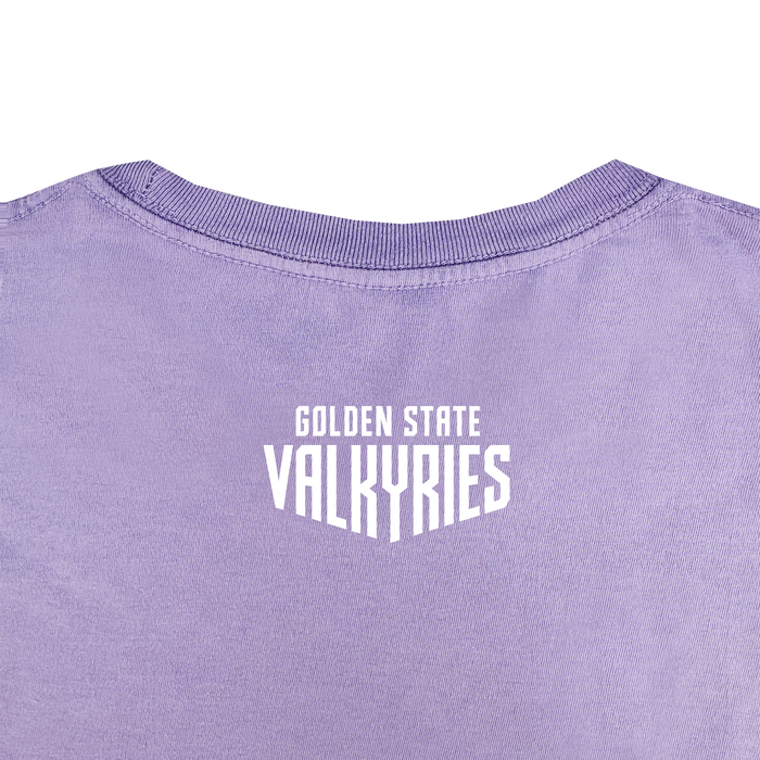 A close-up of the back of the GSV Golden State Valkyries Rec League Premium Tee in lavender organic cotton, featuring bold white "GOLDEN STATE VALKYRIES" text near the neckline, visible fabric texture, and a ribbed collar.