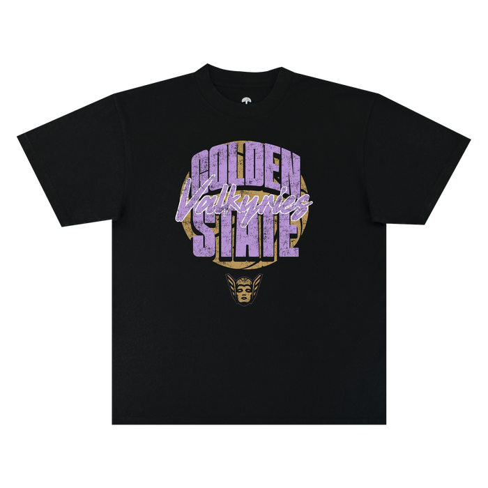 The GSV Fade Away Tee by GSV is a black, 100% cotton classic fit t-shirt featuring bold, distressed “Golden State Valkyries” lettering in purple and white. Beneath the text, a stylized golden Valkyrie face with a winged helmet is printed. The shirt is displayed flat on a white background.