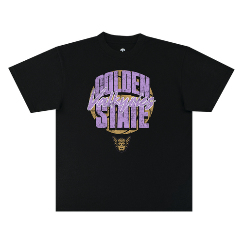 The GSV Fade Away Tee by GSV is a black, 100% cotton classic fit t-shirt featuring bold, distressed “Golden State Valkyries” lettering in purple and white. Beneath the text, a stylized golden Valkyrie face with a winged helmet is printed. The shirt is displayed flat on a white background.