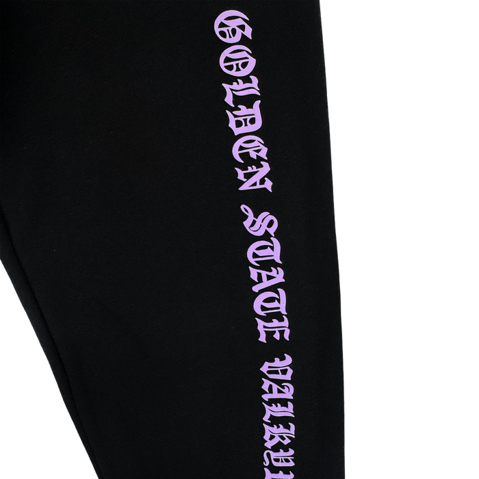 The GSV ROTV Pant by GSV features black fabric, men's sizing, and "GOLDEN STATE VALLEY" printed vertically in bold lilac Old English-style lettering, inspired by the Golden State Valkyries, on a plain white background.