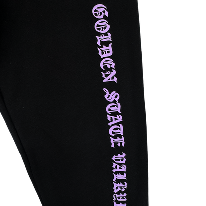 The GSV ROTV Pant by GSV features black fabric, men's sizing, and "GOLDEN STATE VALLEY" printed vertically in bold lilac Old English-style lettering, inspired by the Golden State Valkyries, on a plain white background.