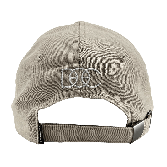 Back view of khaki Oakland Dad Hat designed by Dustin O. Canalin white embroidered DOC wordmark, adjustable strapback, and small Oaklandish wordmark tag.