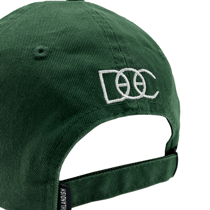 The Happy Oakland Dad Hat by Oaklandish is displayed from the back, showcasing a green corduroy fabric with an adjustable strap and a silver buckle. The back is embroidered with the letters "DCC" in white, featuring a basketball design integrated into the middle "C," reflecting Bay Area culture.