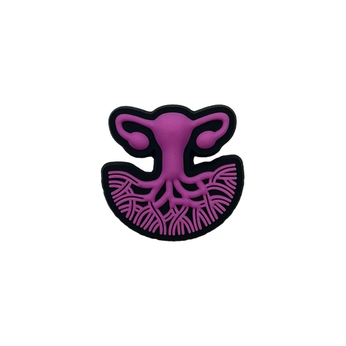 A stylized illustration of the female reproductive system in purple, featuring the uterus, fallopian tubes, and ovaries. The lower section showcases branching blood vessels, while the entire image is outlined in black against a transparent background. This design symbolizes women's healthcare and is presented on the Isha Shoe Charm by Oaklandish.
