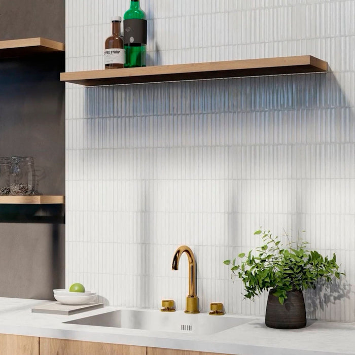 Modern kitchen with white kit kat mosaic tiles on the wall and a gold tap.