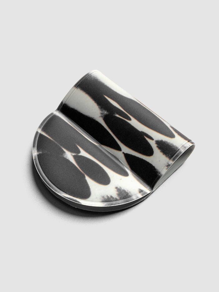 Magnetic Bookmark | Pen Holder | Vinyl in Dissolve, angled view showing high-contrast black and off-white oval pattern