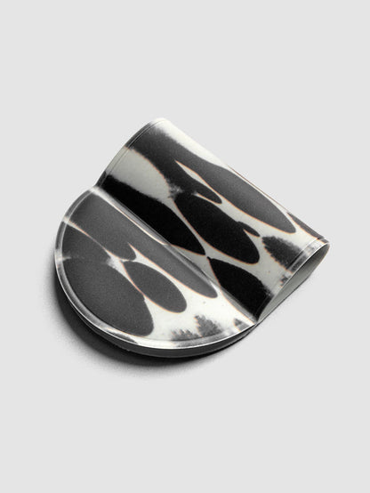 Magnetic Bookmark | Pen Holder | Vinyl in Dissolve, angled view showing high-contrast black and off-white oval pattern
