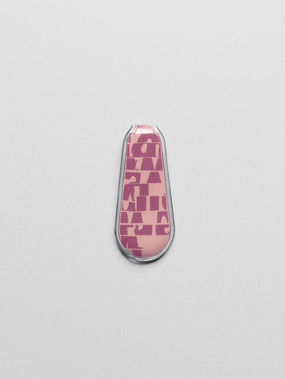 Pink, patterned magnetic bookmark shown closed, laying flat on a neutral background.