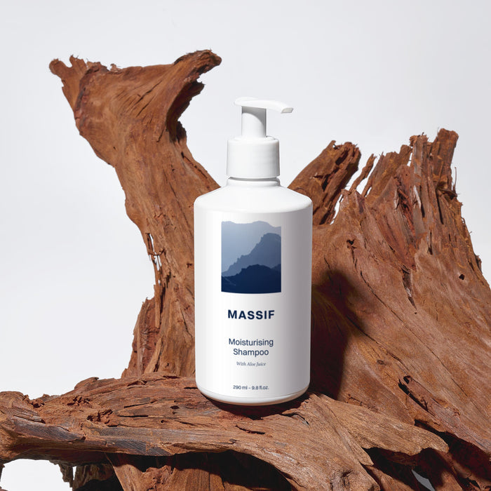 Massif fuktighetsgivende sjampo med aloe i hvit flaske på tre