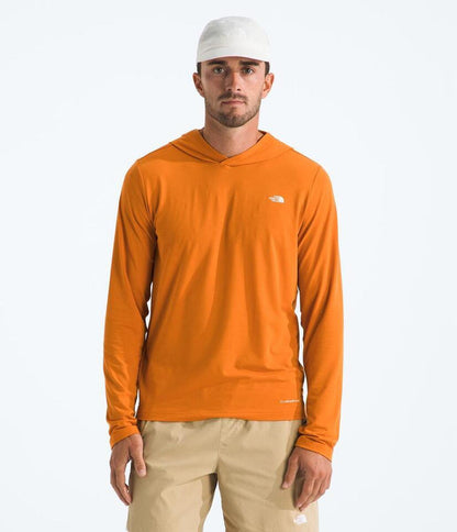 Man wearing an orange long-sleeve shirt with a logo on a white background