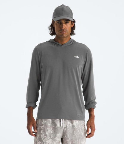 Man wearing a gray hoodie with a logo on a white background