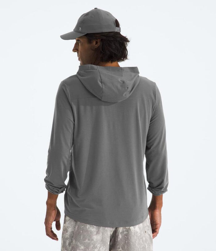 Person wearing a gray hoodie and cap on a light gray background