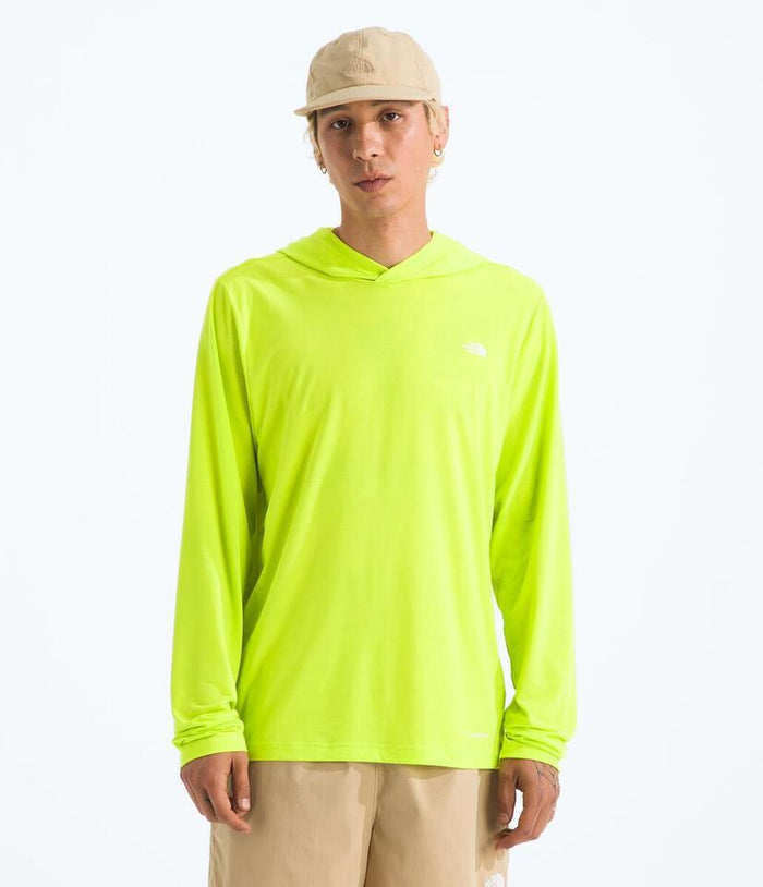 Person wearing a bright green hoodie with a logo on a white background