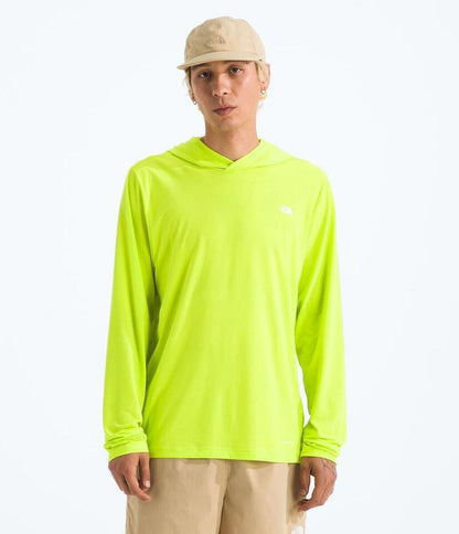 Person wearing a bright green hoodie with a logo on a white background