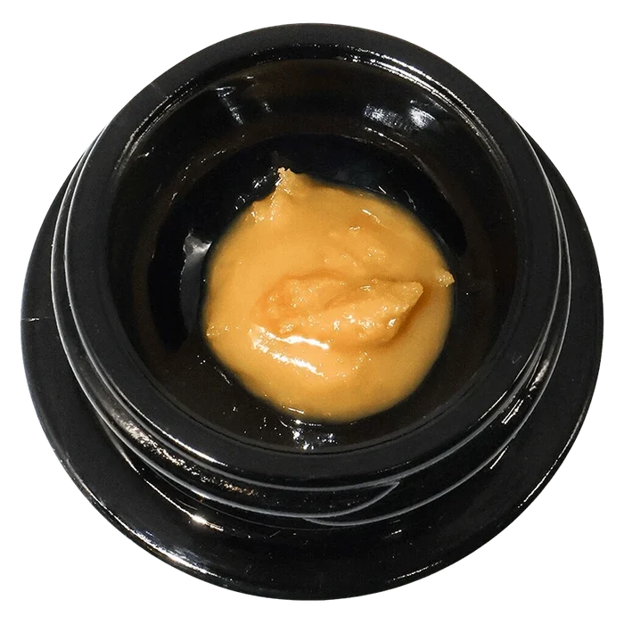 Top-down view of a small black jar holding a glossy dollop of golden concentrate labeled Mochazilla Live Rosin.