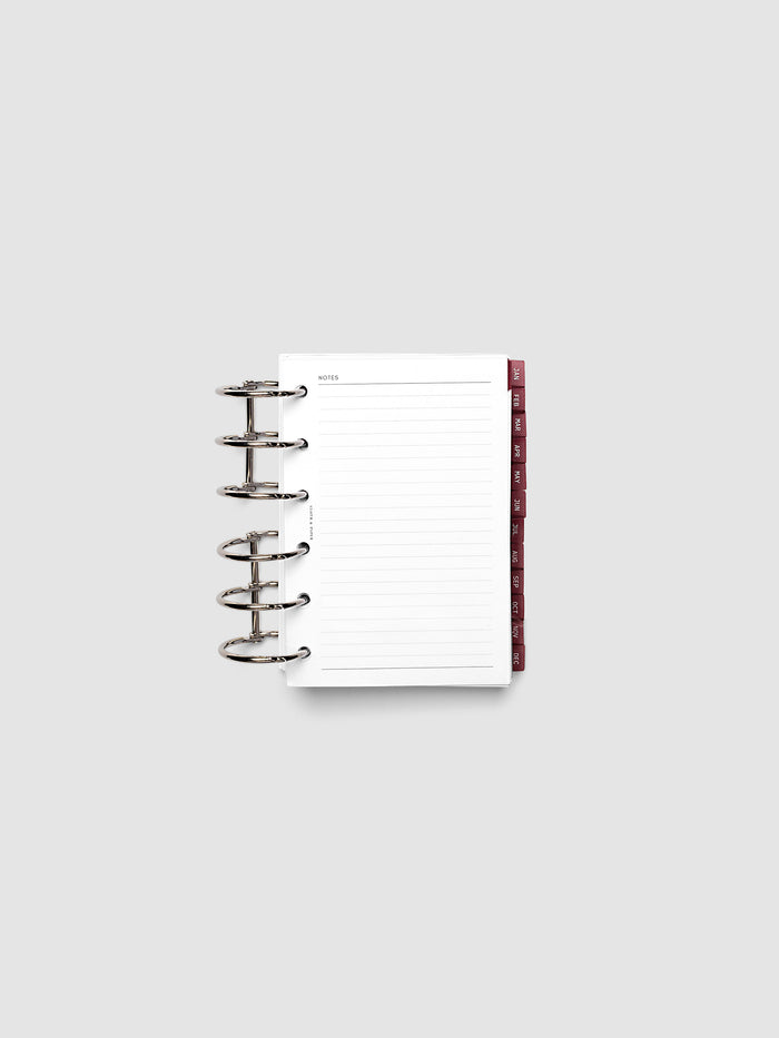 Pocket 6-Ring Punch Ultra-Thin Monthly Dividers in deep red shown tabbed inside a planner