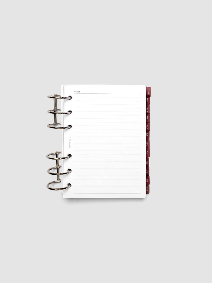 A6 6-Ring Punch Ultra-Thin Monthly Dividers in deep red shown tabbed inside a planner