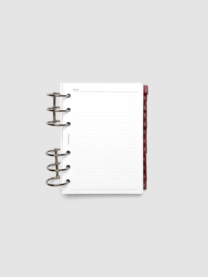 A6 6-Ring Punch Ultra-Thin Monthly Dividers in deep red shown tabbed inside a planner