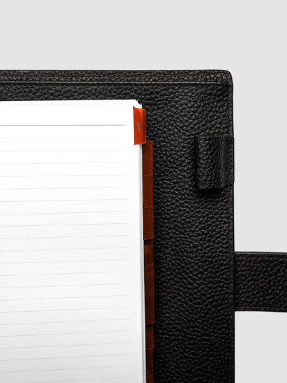Top right corner close-up of deep orange monthly divider in A5 6-Ring Punch planner showing tab label detail