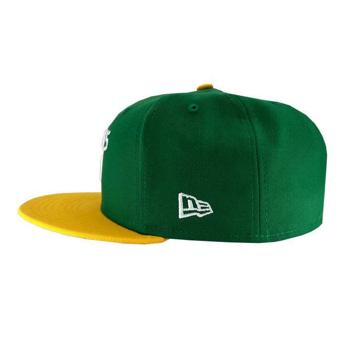 Introducing the New Era Oakland Ballers 59Fifty Cap: a stylish green baseball cap featuring a yellow brim and a small yellow button on top. The cap showcases intricate white stitching, including the iconic New Era logo on the side, making it an ideal accessory for any dedicated Oakland Ballers fan.