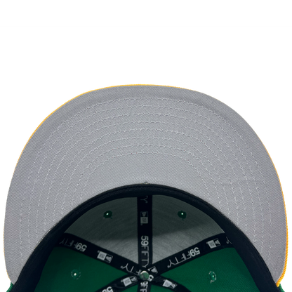 A close-up view of the underside of a New Era Oakland Ballers 59Fifty Cap's brim from their Pioneer League days. The brim is gray with visible stitching and a yellow edge. The interior showcases green fabric and black bands labeled "39THIRTY." Rivets on the green fabric are also evident, against a white background.