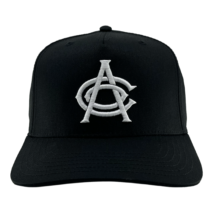 Introducing the OAC Logo 5 Panel by OAC—a black snapback cap featuring a white embroidered logo of interlocking “A” and “C” letters in a bold, stylized font, representing the Oakland Athletic Club. This cap is designed with a curved brim and visible stitching on both the bill and crown, showcased against a plain white background.