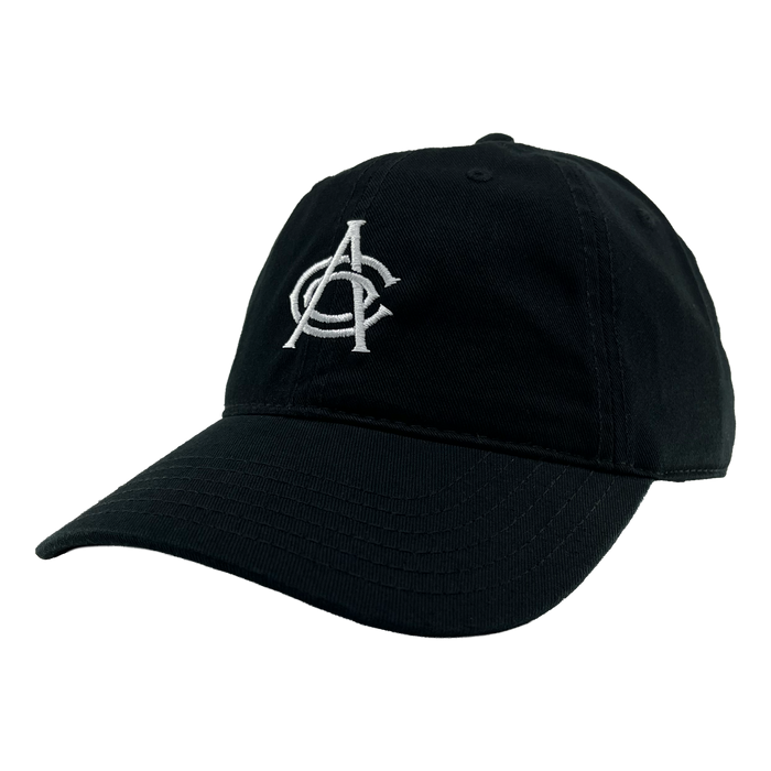 The OAC Logo Dad Hat by OAC is a black cap with a curved brim, highlighted by a white embroidered overlapping “A” and “C” logo on the front, inspired by the Oakland Athletic Club. Displayed against a plain white background, the hat is angled slightly to the left to showcase its front and side panels as well as an adjustable strap at the back for a comfortable fit.