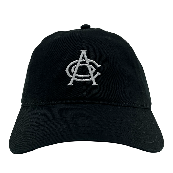 The OAC Logo Dad Hat by OAC is a black dad hat with white embroidered overlapping letters “A” and “C” on the front, symbolizing the Oakland Athletic Club. It features visible stitching along the slightly curved brim and includes an adjustable strap at the back. The product is shown against a plain white background.