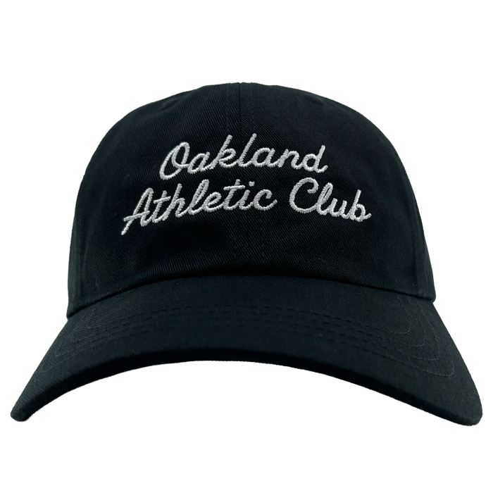 A front view of the OAC Script Dad Hat by OAC, in black, featuring “Oakland Athletic Club” embroidered in white cursive on the front and an adjustable back strap, set against a plain white background.